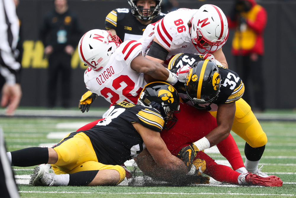 Iowa Hawkeyes defensive end Anthony Nelson (98) and Iowa Hawkeyes linebacker Djimon Colbert (32) make a tackle during a game against Nebraska at Kinnick Stadium on November 23, 2018. (Tork Mason/hawkeyesports.com)