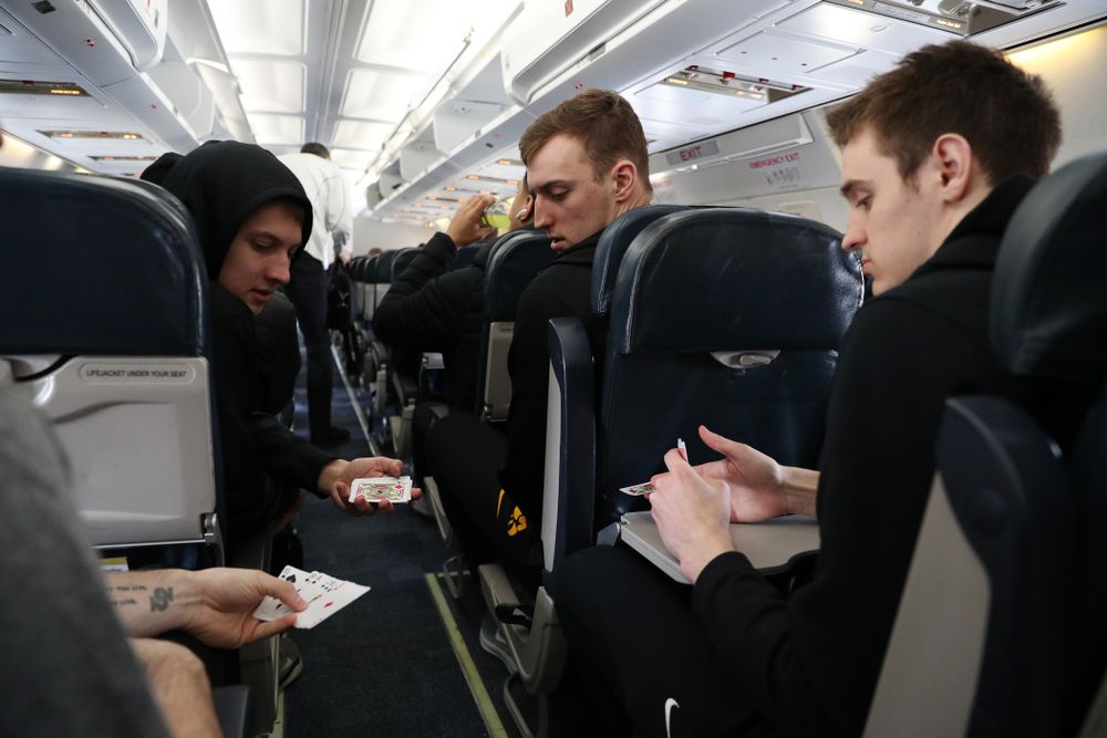 Iowa Hawkeyes guard Connor McCaffery (30), guard Austin Ash (13), forward Jack Nunge (2) forward Nicholas Baer (51) play cards on a flight to Columbus for the first and second rounds of the 2019 NCAA Men's Basketball Tournament Wednesday, March 20, 2019 at the Eastern Iowa Airport. (Brian Ray/hawkeyesports.com)