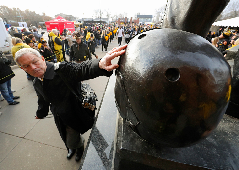 Iowa Hawkeyes head coach Kirk Ferentz touches the helmet on the Nile Kinnick statue before their game at Kinnick Stadium in Iowa City on Saturday, Nov 23, 2019. (Stephen Mally/hawkeyesports.com)