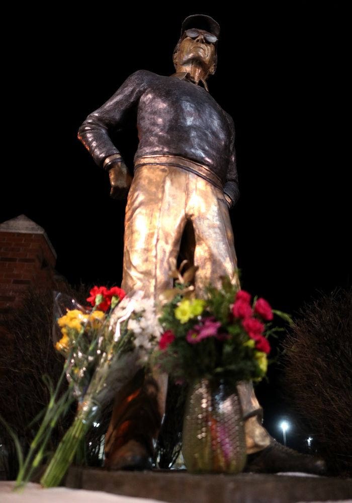 Mourners lay flowers at the statue of former Hawkeye Football Head Coach Hayden Fry Tuesday, December 17, 2019 in Coralville. Fry passed away on Tuesday at the age of 90. (Brian Ray/hawkeyesports.com)