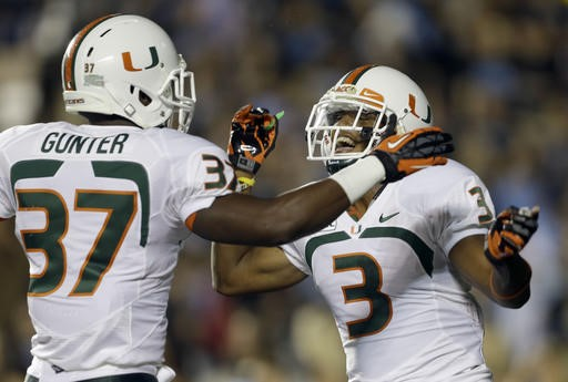 Miami's Ladarius Gunter (37) and Tracy Howard (3)celebrate Howard's interception against North Carolina during the first half of an NCAA college...