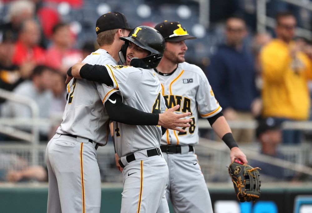 Iowa Hawkeyes infielder Mitchell Boe (4) hugs infielder Brendan Sher (2) after scoring against the Indiana Hoosiers in the first round of the Big Ten Baseball Tournament Wednesday, May 22, 2019 at TD Ameritrade Park in Omaha, Neb. (Brian Ray/hawkeyesports.com)