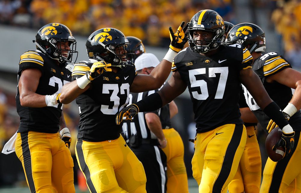 Iowa Hawkeyes defensive back Amani Hooker (27), Iowa Hawkeyes linebacker Djimon Colbert (32), Iowa Hawkeyes defensive end Chauncey Golston (57)