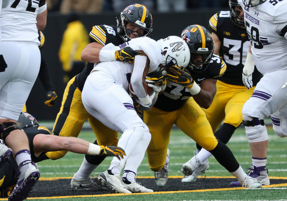 Iowa Hawkeyes linebacker Jack Hockaday (48) and Iowa Hawkeyes linebacker Djimon Colbert (32) make a tackle during a game against Northwestern at Kinnick Stadium on November 10, 2018. (Tork Mason/hawkeyesports.com)