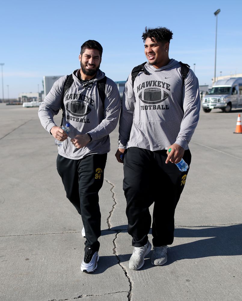 Iowa Hawkeyes defensive end A.J. Epenesa (94) and offensive lineman Tristan Wirfs (74) board the team plane at the Eastern Iowa Airport Saturday, December 21, 2019 on the way to San Diego, CA for the Holiday Bowl. (Brian Ray/hawkeyesports.com)