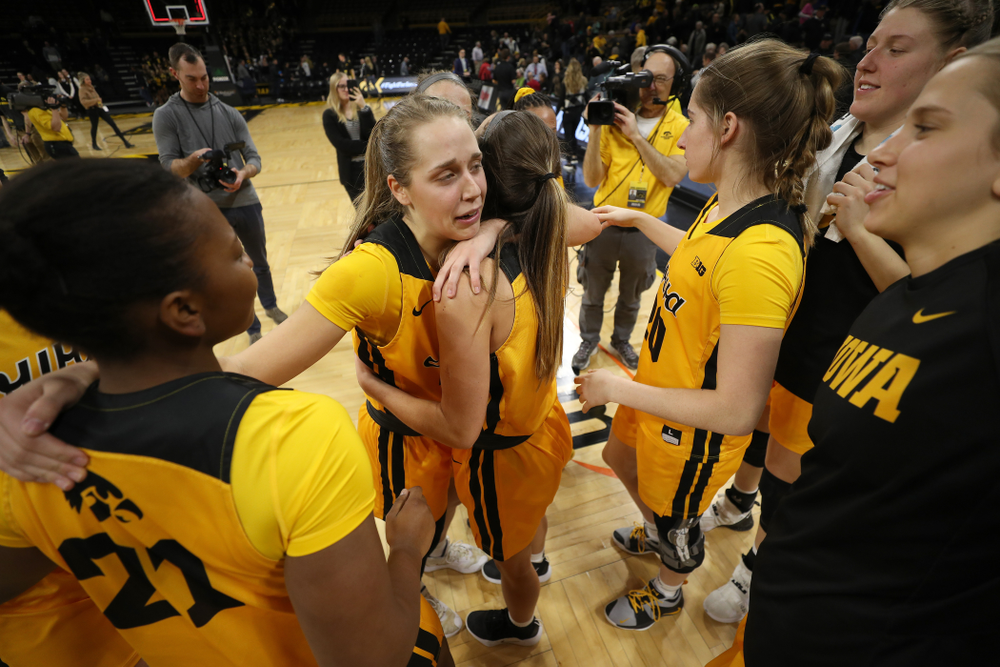 Iowa Hawkeyes guard Kathleen Doyle (22) hugs guard Megan Meyer (11) and guard Zion Sanders (21) during senior day activities following their win over the Minnesota Golden Gophers Thursday, February 27, 2020 at Carver-Hawkeye Arena. (Brian Ray/hawkeyesports.com)
