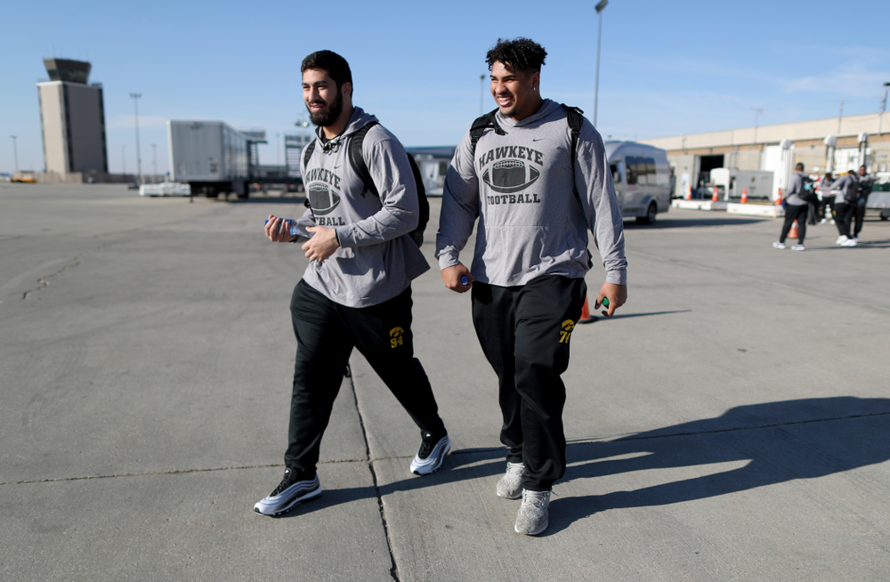 Iowa Hawkeyes defensive end A.J. Epenesa (94) and offensive lineman Tristan Wirfs (74) board the team plane at the Eastern Iowa Airport Saturday, December 21, 2019 on the way to San Diego, CA for the Holiday Bowl. (Brian Ray/hawkeyesports.com)
