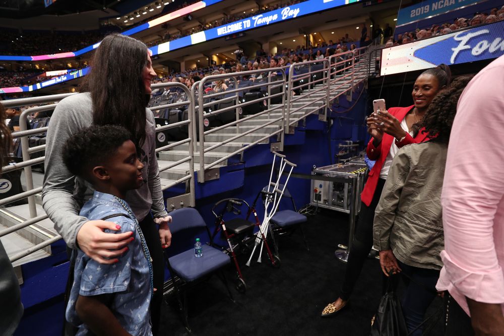 Iowa Hawkeyes forward Megan Gustafson (10) talks with Lisa Leslie and her family before being introduced during a timeout in the second half of the National Semi-Final between Baylor and Oregon Friday, April 5, 2019 at Amalie Arena in Tampa, FL. (Brian Ray/hawkeyesports.com)