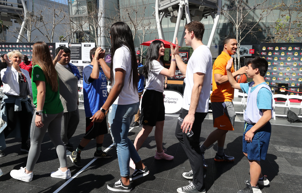 Iowa Hawkeyes forward Megan Gustafson (10) high fives WisconsinÕs Ethan Happ during a Special Olympics event Friday, April 12, 2019 as part of the ESPN College Basketball Awards in the XBOX Plaza at LA Live. (Brian Ray/hawkeyesports.com)