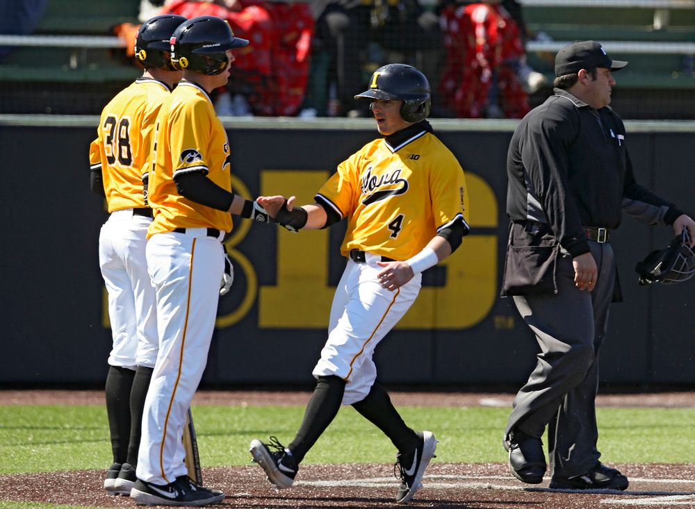 Iowa Hawkeyes infielder Mitchell Boe (right) slaps hands with Zeb Adreon (left) after they both scored during the third inning against Illinois at Duane Banks Field in Iowa City on Sunday, Mar. 31, 2019. (Stephen Mally/hawkeyesports.com)