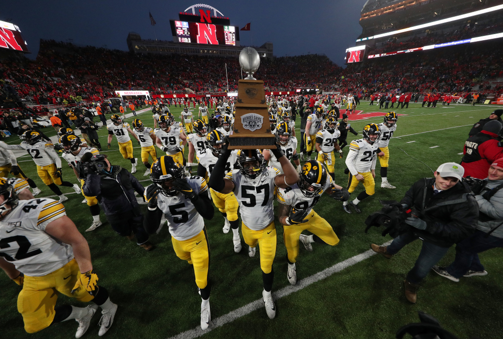 Iowa Hawkeyes defensive end Chauncey Golston (57) carries the Heroes Game trophy off the field following their win against the Nebraska Cornhuskers Friday, November 29, 2019 at Memorial Stadium in Lincoln, Neb. (Brian Ray/hawkeyesports.com)