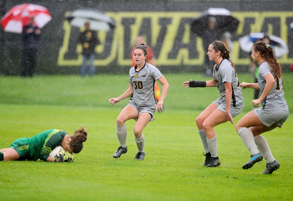 Northwestern goalkeeper Mackenzie Wood (1) falls on a shot as Iowa forward Devin Burns (30), midfielder Josie Durr (25), and defender Hannah Drkulec (17) close in during the second half of their match at the Iowa Soccer Complex in Iowa City on Sunday, Sep 29, 2019. (Stephen Mally/hawkeyesports.com)