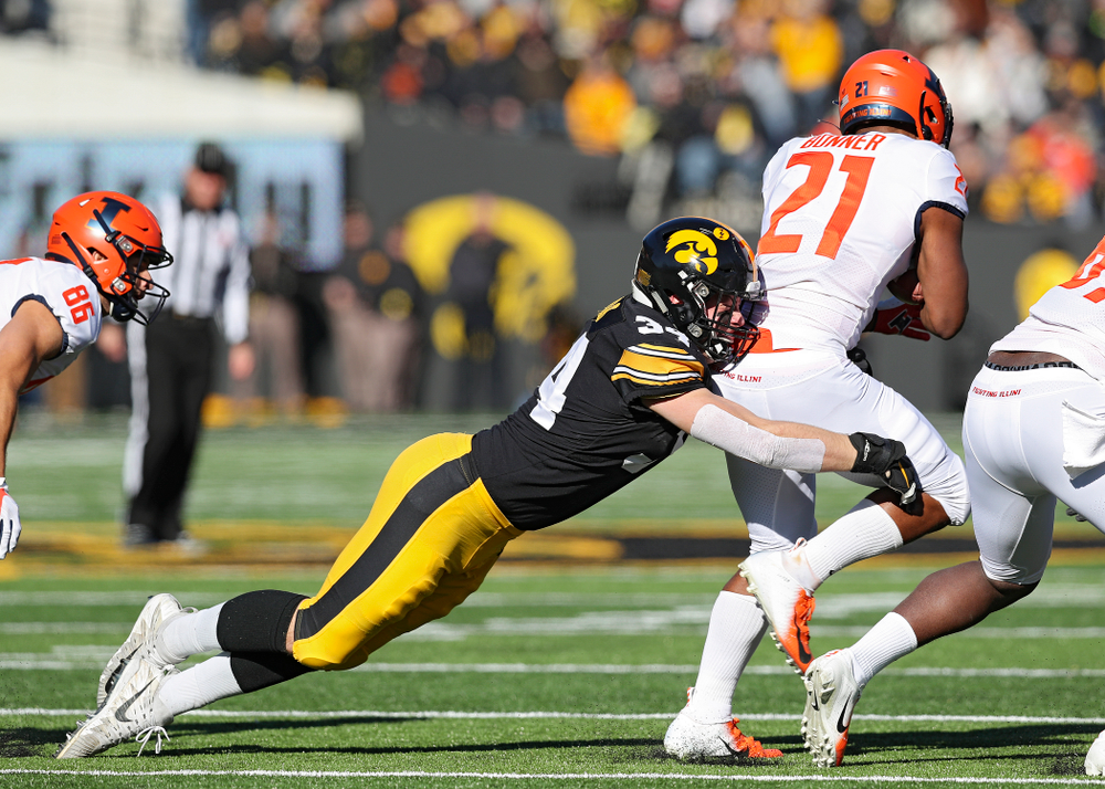 Iowa Hawkeyes linebacker Kristian Welch (34) pulls down Illinois Fighting Illini running back Ra'Von Bonner (21) during the first quarter of their game at Kinnick Stadium in Iowa City on Saturday, Nov 23, 2019. (Stephen Mally/hawkeyesports.com)