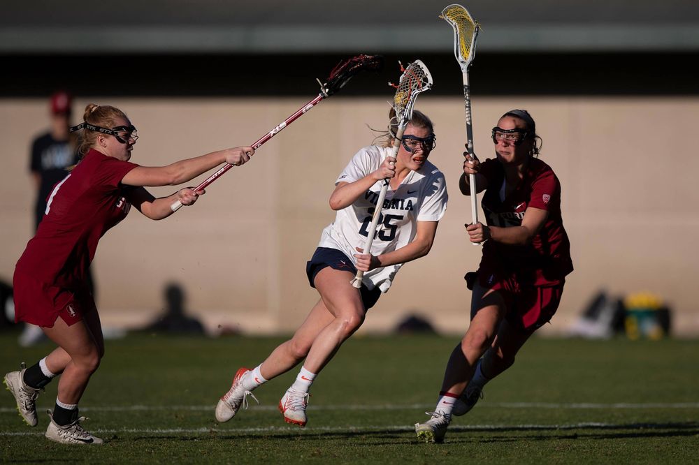 STANFORD, California - FEBRUARY 14: Virginia Cavaliers midfield Courtlynne Caskin (25) is defended by Stanford Cardinal defense Maggie Bellaschi (11) and midfield Chelsea Trattner (16) during the second half at Cagan Stadium on February 14, 2020 in Stanford, California. The Virginia Cavaliers defeated the Stanford Cardinal 12-11. (Photo by Jason O. Watson)
