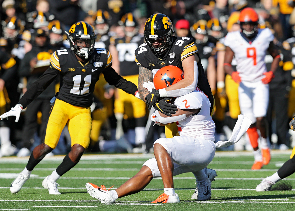 Iowa Hawkeyes defensive end A.J. Epenesa (94) wraps up Illinois Fighting Illini running back Reggie Corbin (2) during the first quarter of their game at Kinnick Stadium in Iowa City on Saturday, Nov 23, 2019. (Stephen Mally/hawkeyesports.com)