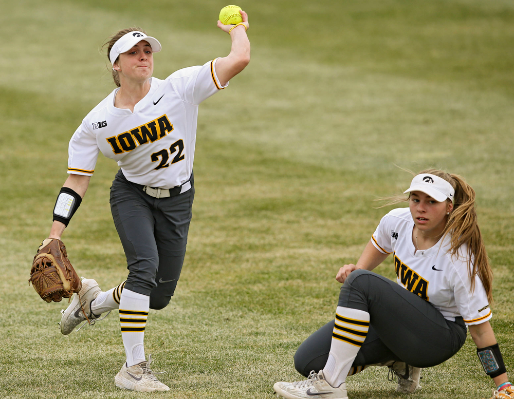 Iowa Hawkeyes Hallie Ketcham (22) throws the ball as Sydney Owens (5) looks on during the second inning of their Big Ten Conference softball game at Pearl Field in Iowa City on Friday, Mar. 29, 2019. (Stephen Mally/hawkeyesports.com)