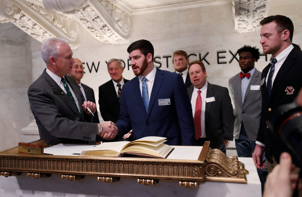 Iowa Hawkeyes linebacker Josey Jewell (43), defensive back Joshua Jackson (15), offensive lineman Sean Welsh (79) and head coach Kirk Ferentz ring the opening bell at the New York Stock Exchange Tuesday, December 26, 2017 in New York. (Brian Ray/hawkeyesports.com)