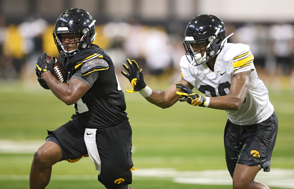 Iowa Hawkeyes running back Ivory Kelly-Martin (21) runs after pulling in a pass as defensive back Kaevon Merriweather (26) closes in during Fall Camp Practice No. 9 at the Hansen Football Performance Center in Iowa City on Monday, Aug 12, 2019. (Stephen Mally/hawkeyesports.com)
