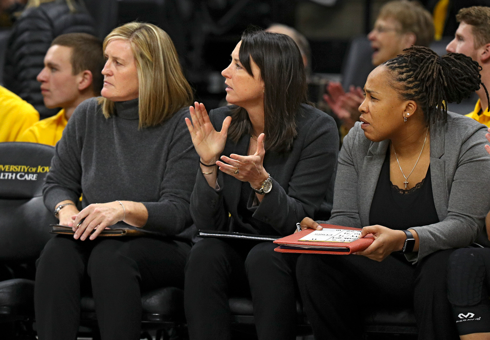 Iowa assistant coach Abby Stamp (center) claps between special assistant to the head coach Jenni Fitzgerald (left) and assistant coach Raina Harmon (right) during the third quarter of their overtime win against Princeton at Carver-Hawkeye Arena in Iowa City on Wednesday, Nov 20, 2019. (Stephen Mally/hawkeyesports.com)