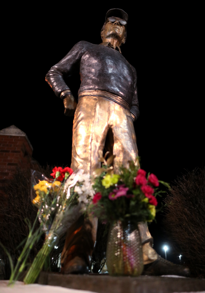 Mourners lay flowers at the statue of former Hawkeye Football Head Coach Hayden Fry Tuesday, December 17, 2019 in Coralville. Fry passed away on Tuesday at the age of 90. (Brian Ray/hawkeyesports.com)