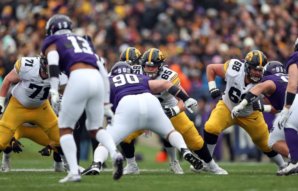 Iowa Hawkeyes offensive lineman Mark Kallenberger (71), offensive lineman Tyler Linderbaum (65), and offensive lineman Landan Paulsen (68) against the Northwestern Wildcats Saturday, October 26, 2019 at Ryan Field in Evanston, Ill. (Brian Ray/hawkeyesports.com)