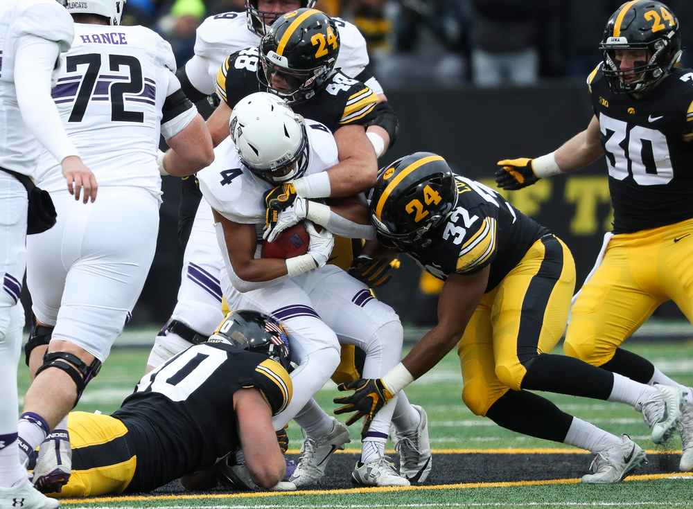Iowa Hawkeyes defensive end Parker Hesse (40), Iowa Hawkeyes linebacker Jack Hockaday (48) and Iowa Hawkeyes linebacker Djimon Colbert (32) make a tackle during a game against Northwestern at Kinnick Stadium on November 10, 2018. (Tork Mason/hawkeyesports.com)