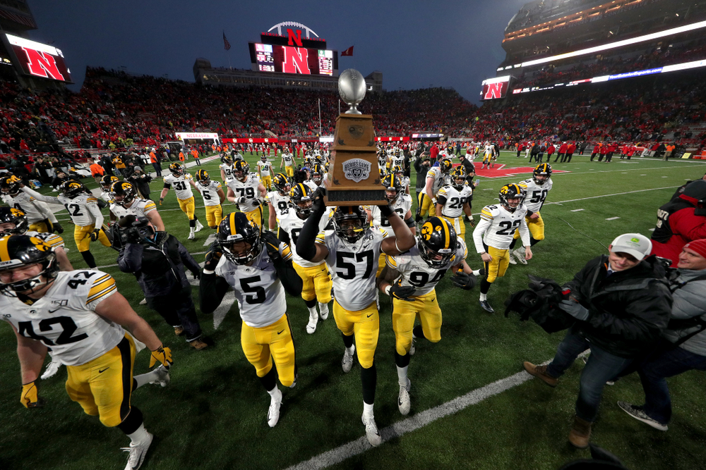 The Iowa Hawkeyes celebrate with the Heroes Game trophy following their win against the Nebraska Cornhuskers Friday, November 29, 2019 at Memorial Stadium in Lincoln, Neb. (Brian Ray/hawkeyesports.com)