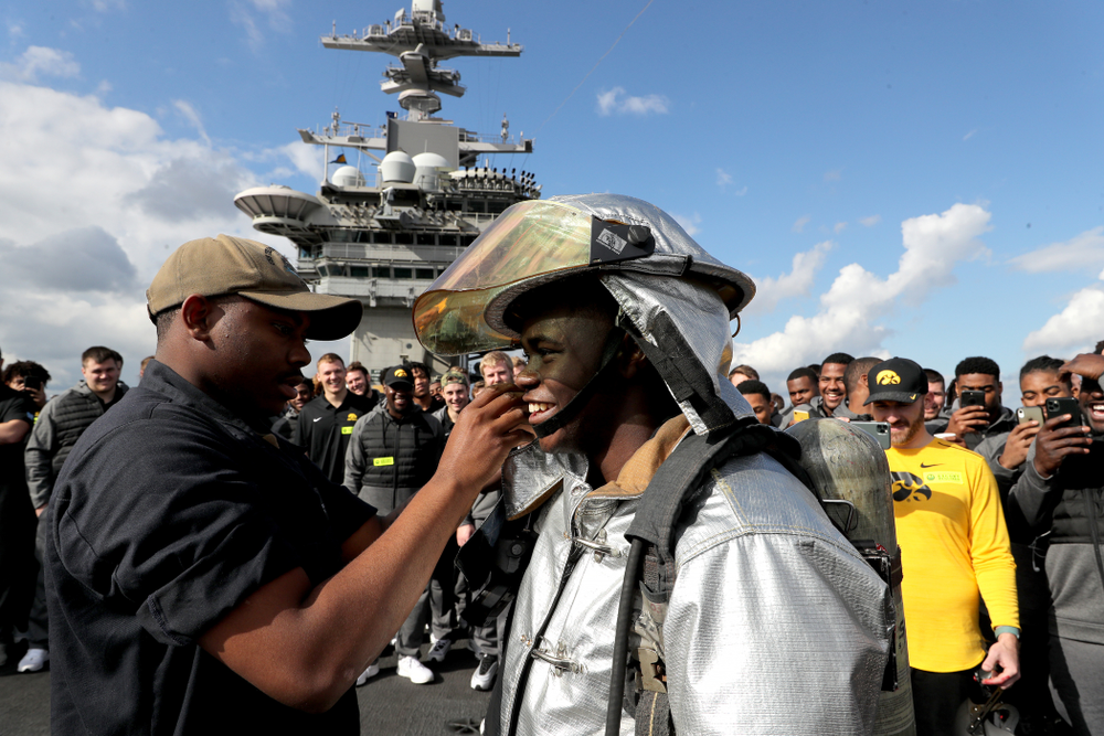 Iowa Hawkeyes running back Keontae Luckett (20) puts on a firefighting suit during a tour of the USS Theodore Roosevelt (CVN-71) Tuesday, December 24, 2019 at the Naval Base Coronado. (Brian Ray/hawkeyesports.com)