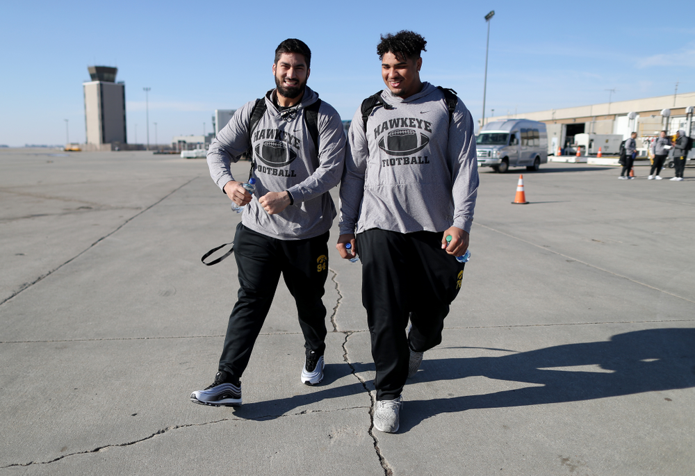 Iowa Hawkeyes defensive end A.J. Epenesa (94) and offensive lineman Tristan Wirfs (74) board the team plane at the Eastern Iowa Airport Saturday, December 21, 2019 on the way to San Diego, CA for the Holiday Bowl. (Brian Ray/hawkeyesports.com)