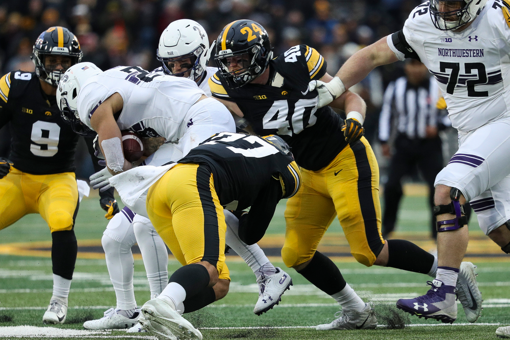 Iowa Hawkeyes defensive back Amani Hooker (27) and Iowa Hawkeyes defensive end Parker Hesse (40) make a tackle during a game against Northwestern at Kinnick Stadium on November 10, 2018. (Tork Mason/hawkeyesports.com)
