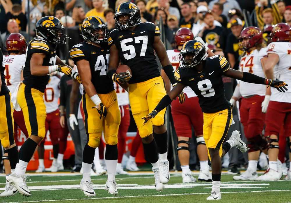 Iowa Hawkeyes linebacker Jack Hockaday (48), Iowa Hawkeyes defensive end Chauncey Golston (57), Iowa Hawkeyes defensive back Matt Hankins (8)