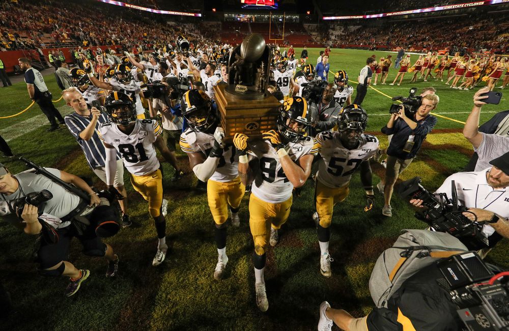 Iowa Hawkeyes defensive end Chauncey Golston (57) and defensive end A.J. Epenesa (94) celebrate with the Cy-Hawk trophy following their win over the Iowa State Cyclones Saturday, September 14, 2019 in Ames, Iowa. (Brian Ray/hawkeyesports.com)