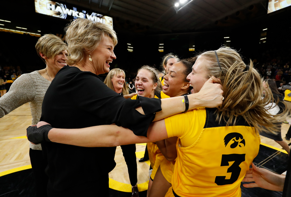 Iowa Hawkeyes head coach Lisa Bluder, guard Makenzie Meyer (3), guard Alexis Sevillian (5), and guard Kathleen Doyle (22)