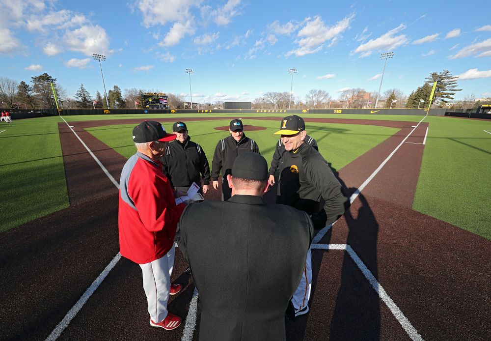 Iowa Hawkeyes head coach Rick Heller meets with the umpires before their game at Duane Banks Field in Iowa City on Tuesday, March 3, 2020. (Stephen Mally/hawkeyesports.com)
