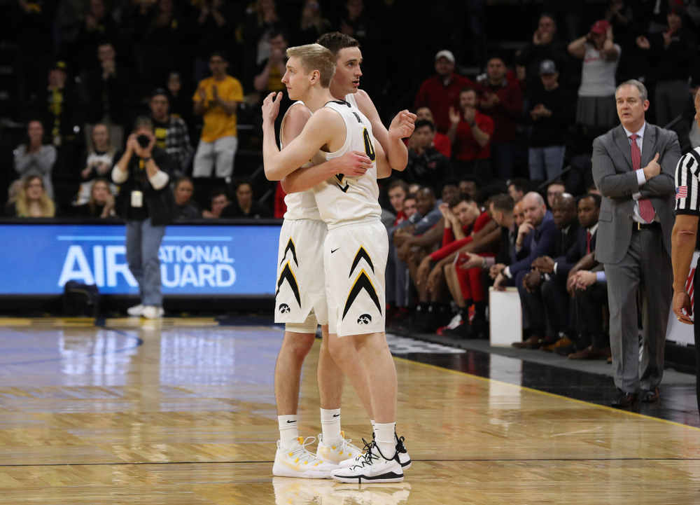 Iowa Hawkeyes forward Nicholas Baer (51) hugs his brother forward Michael Baer (0) as he leaves the court for the final time against the Rutgers Scarlet Knights Saturday, March 2, 2019 at Carver-Hawkeye Arena. (Brian Ray/hawkeyesports.com)