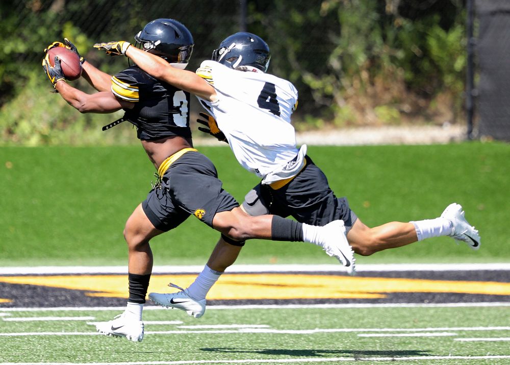 Iowa Hawkeyes wide receiver Tyrone Tracy Jr. (3) pulls in a pass around the hand of defensive back Dane Belton (4) during Fall Camp Practice No. 7 at the Hansen Football Performance Center in Iowa City on Friday, Aug 9, 2019. (Stephen Mally/hawkeyesports.com)