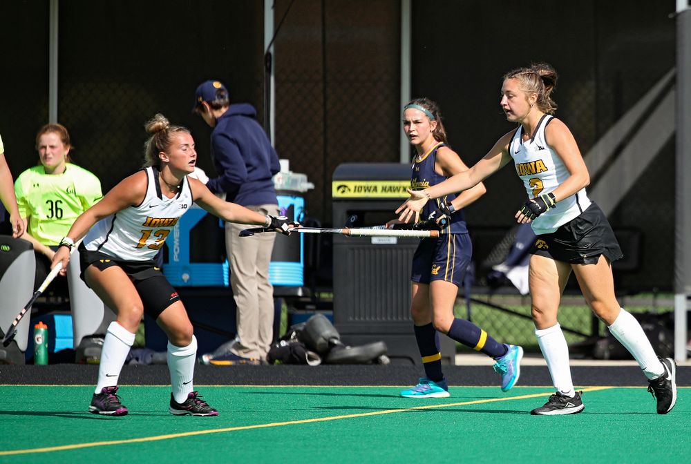 Iowa’s Leah Zellner (13) hands Emily Deuell (2) her stick during the second quarter of their game at Grant Field in Iowa City on Friday, Sep 13, 2019. (Stephen Mally/hawkeyesports.com)