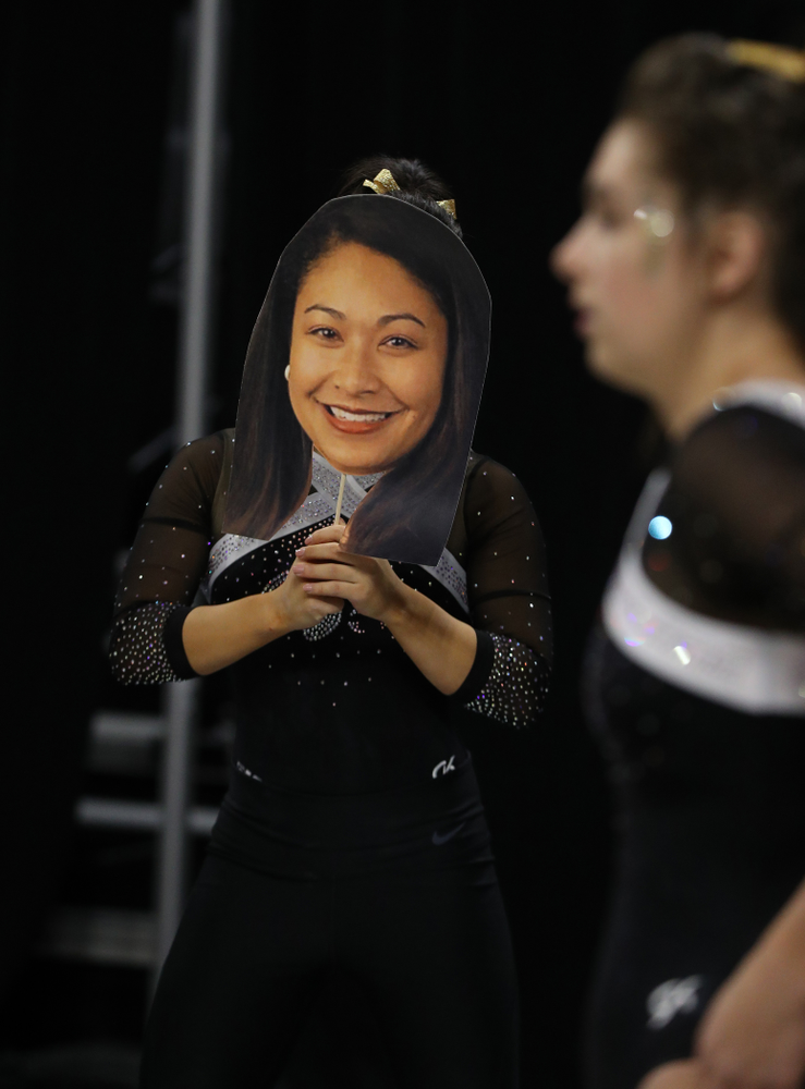 Iowa's Clair Kaji holds a photo of head coach Larissa Libby during their meet against the Rutgers Scarlet Knights Saturday, January 26, 2019 at Carver-Hawkeye Arena. (Brian Ray/hawkeyesports.com)