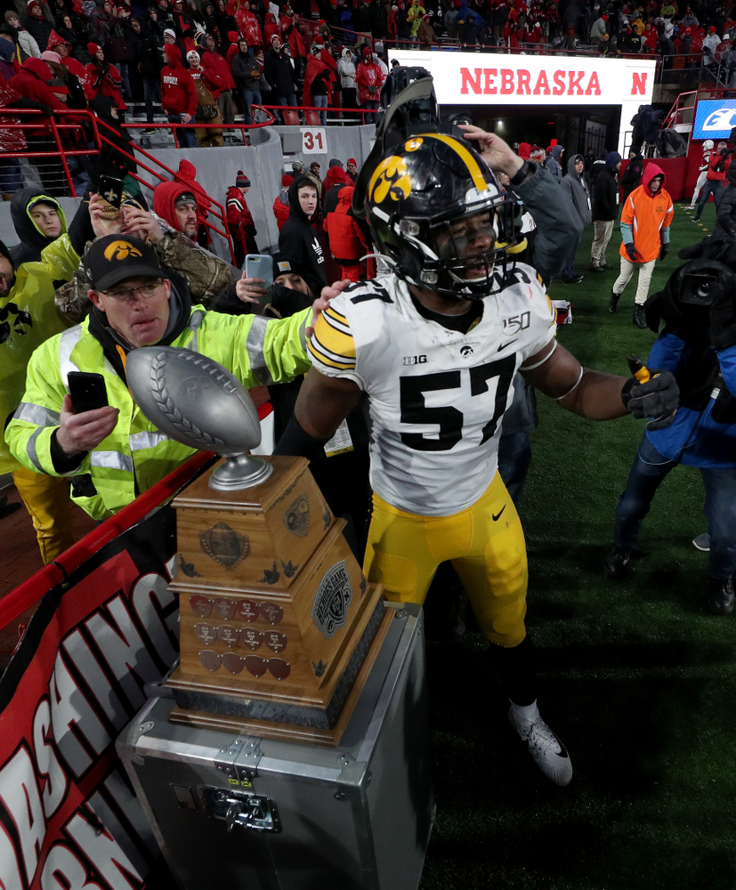 Iowa Hawkeyes defensive end Chauncey Golston (57) carries the Heroes Game trophy off the field following their win against the Nebraska Cornhuskers Friday, November 29, 2019 at Memorial Stadium in Lincoln, Neb. (Brian Ray/hawkeyesports.com)
