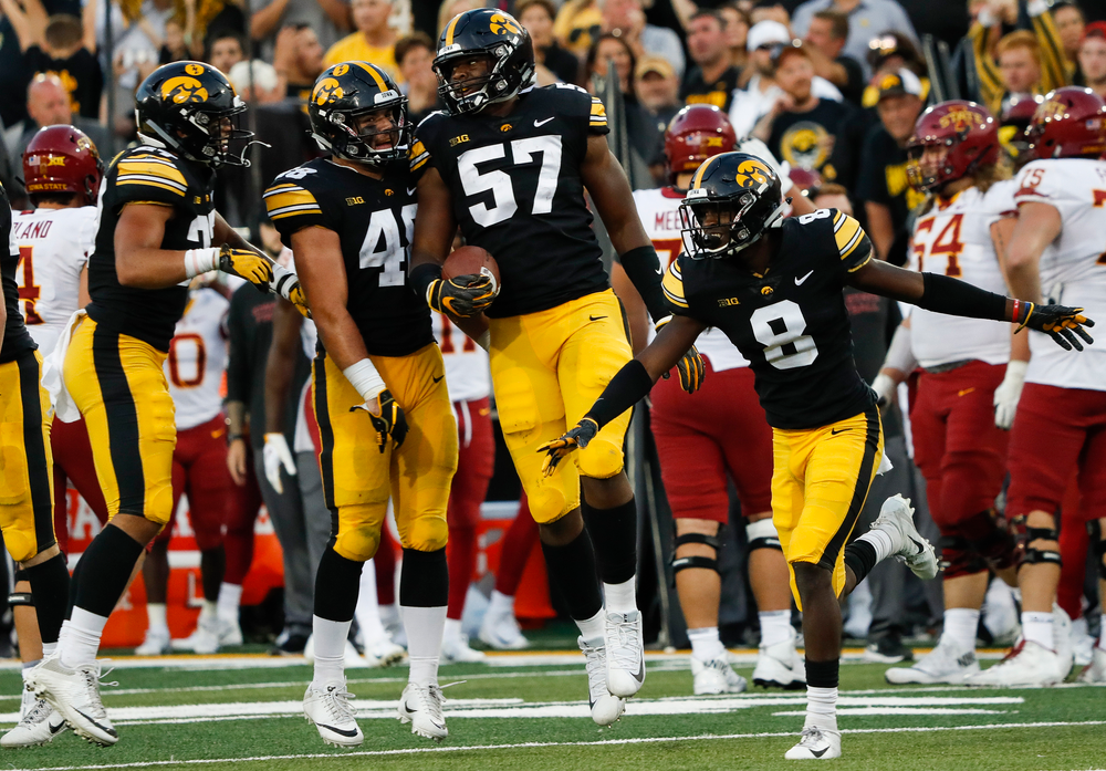 Iowa Hawkeyes linebacker Jack Hockaday (48), Iowa Hawkeyes defensive end Chauncey Golston (57), Iowa Hawkeyes defensive back Matt Hankins (8)