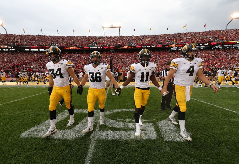 Captains linebacker Kristian Welch (34), fullback Brady Ross (36), defensive back Michael Ojemudia (11), and quarterback Nate Stanley (4) against the Iowa State Cyclones Saturday, September 14, 2019 at Jack Trice Stadium in Ames, Iowa. (Brian Ray/hawkeyesports.com)