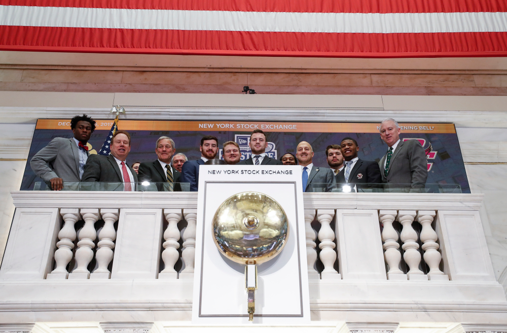 Iowa Hawkeyes linebacker Josey Jewell (43), defensive back Joshua Jackson (15), offensive lineman Sean Welsh (79) and head coach Kirk Ferentz ring the opening bell at the New York Stock Exchange Tuesday, December 26, 2017 in New York. (Brian Ray/hawkeyesports.com)