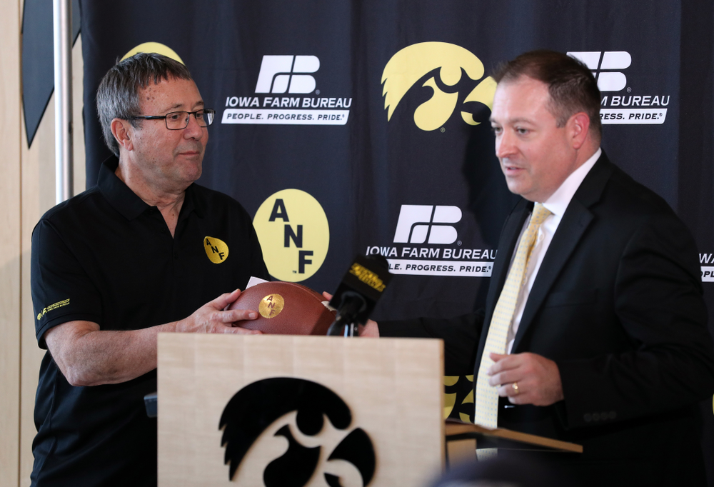 Iowa Farm Bureau Executive Director Joe Johnson receives a game ball from associate athletics director for strategic communications and marketing Charlie Taylor Tuesday, October 8, 2019 at the Hansen Football Performance Center. (Brian Ray/hawkeyesports.com)
