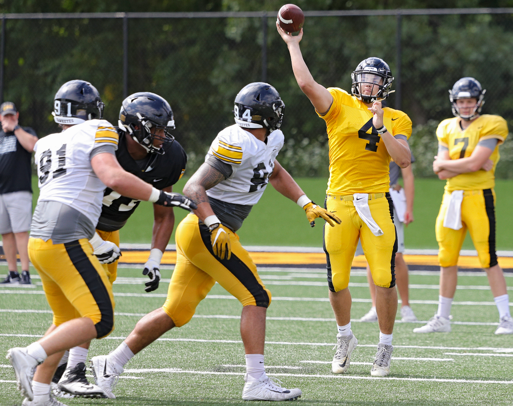 Iowa Hawkeyes quarterback Nate Stanley (4) throws a pass over defensive end A.J. Epenesa (94) during Fall Camp Practice No. 11 at the Hansen Football Performance Center in Iowa City on Wednesday, Aug 14, 2019. (Stephen Mally/hawkeyesports.com)