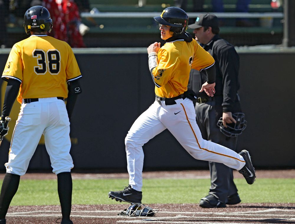 Iowa Hawkeyes catcher Austin Martin (right) scores a run on a wild pitch during Trenton Wallace's (38) at bat during the third inning against Illinois at Duane Banks Field in Iowa City on Sunday, Mar. 31, 2019. (Stephen Mally/hawkeyesports.com)