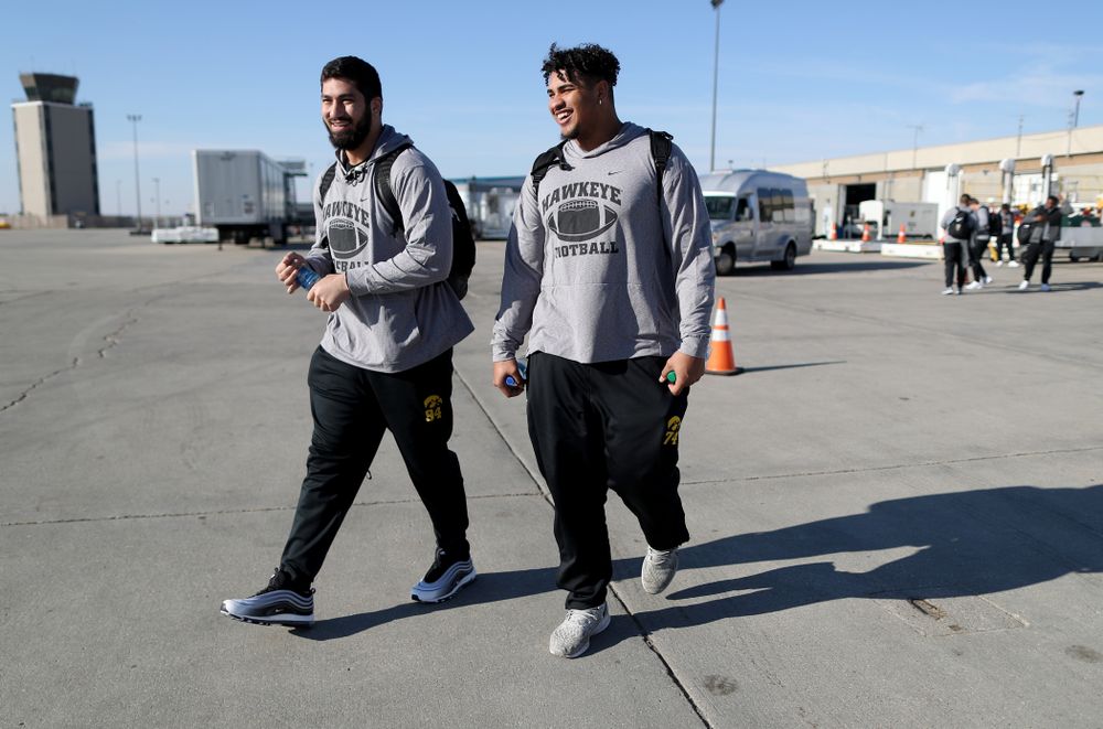 Iowa Hawkeyes defensive end A.J. Epenesa (94) and offensive lineman Tristan Wirfs (74) board the team plane at the Eastern Iowa Airport Saturday, December 21, 2019 on the way to San Diego, CA for the Holiday Bowl. (Brian Ray/hawkeyesports.com)