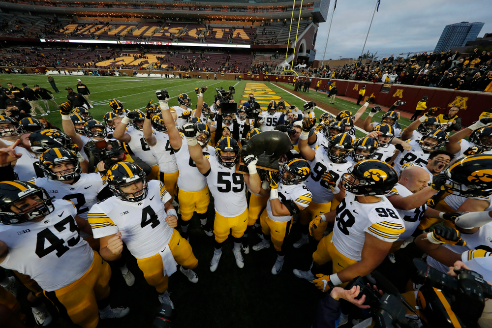 The Iowa Hawkeyes celebrate with the Floyd of Rosedale trophy following their win over the Minnesota Golden Gophers Saturday, October 6, 2018 at TCF Bank Stadium. (Brian Ray/hawkeyesports.com)
