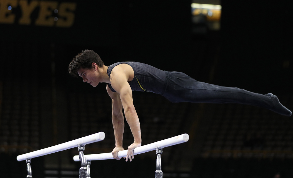 Iowa's Evan Davis competes on the parallel bars against the Ohio State Buckeyes Saturday, March 16, 2019 at Carver-Hawkeye Arena. (Brian Ray/hawkeyesports.com)